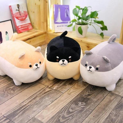 Yellow angry shiba plush pillow with black in centre and gray shiba plush on right