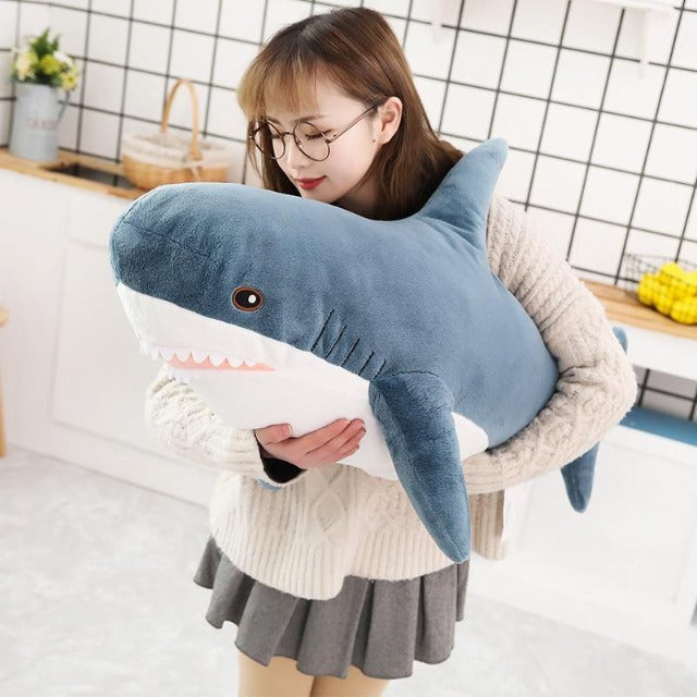 woman cradling a kawai shark plush in her hands