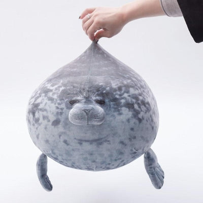 A fat seal plush being held with a hand