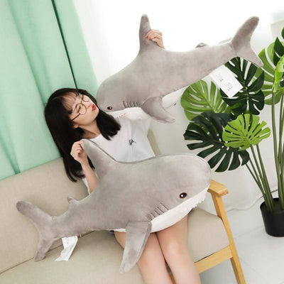 Woman playing with gray shark stuffed animals