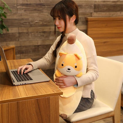 Woman sitting on a chair on a laptop holding a banana plush