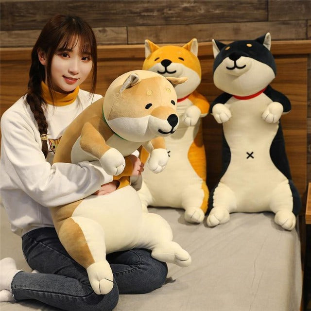 Woman holding a shiba plush giving it a hug