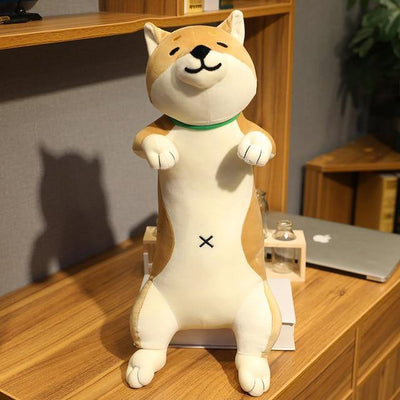 A light brown shiba toy sitting on a book
