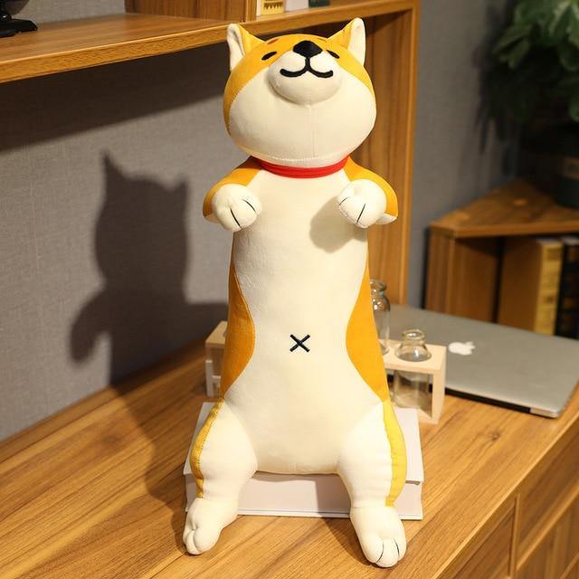 Light brown shiba plushie with a smile sitting on a book