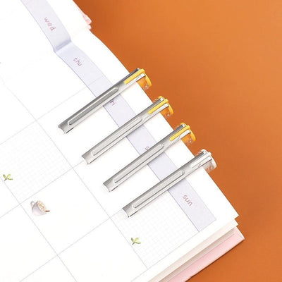 Pens hooked onto a diary via the lid