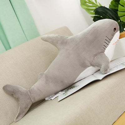 Gray shark plush toy an the sofa