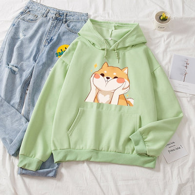 Green fleece hoodie with a design of a smiling shiba