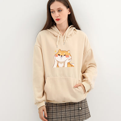woman wearing a cream hoodie with a shiba design