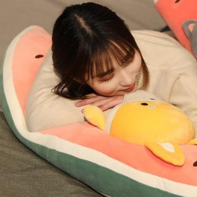 A woman laying on a melon plushie with a shiba inus face on it