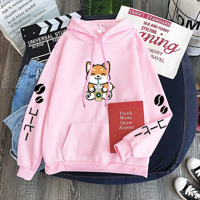 pink shiba sitting down on a hoodie
